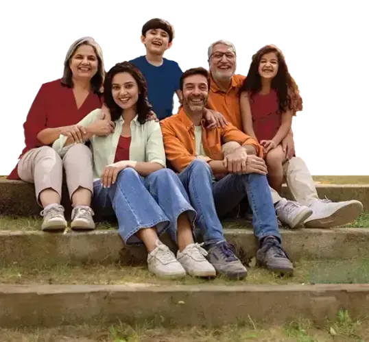 Smiling multi-generation family seated on outdoor steps, arms around each other, posing together happily.