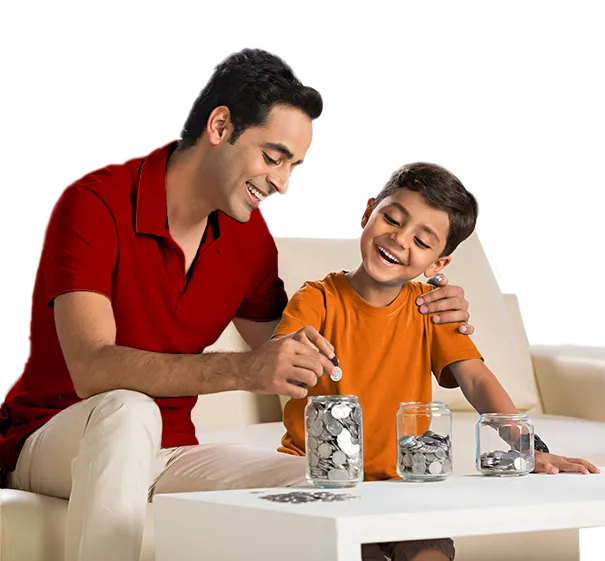 Father teaching son to save coins at table, orange backdrop