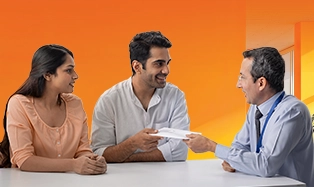 Businessman in suit smiling while working on laptop in office.