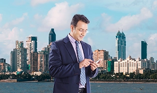 Businessman in suit checking smartphone with city skyline in background.