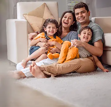 Home loan ad: Easy online sanction with minimal documentation. Happy family of four hugging on a sofa.