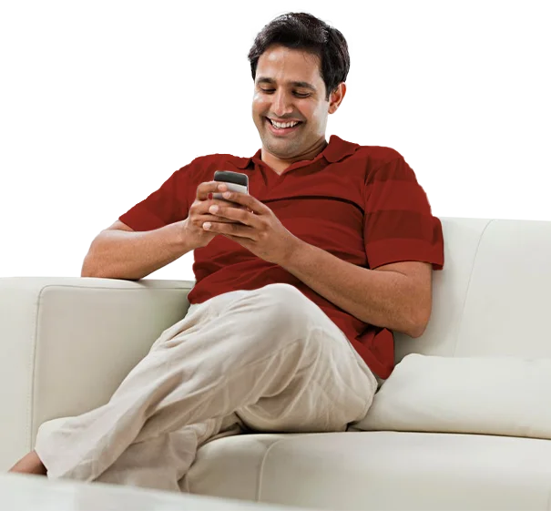 Man relaxing in armchair using mobile at office desk