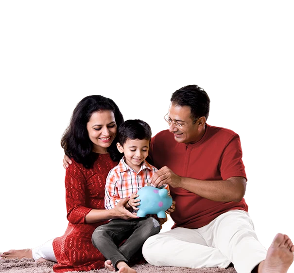 Parents help a smailing boy put coins into a blue piggy bank while sitting together on the floor.