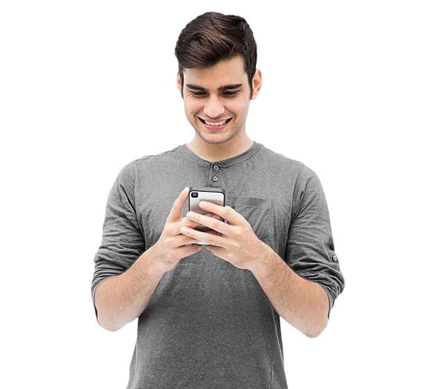 Smiling young man using smartphone against black background.