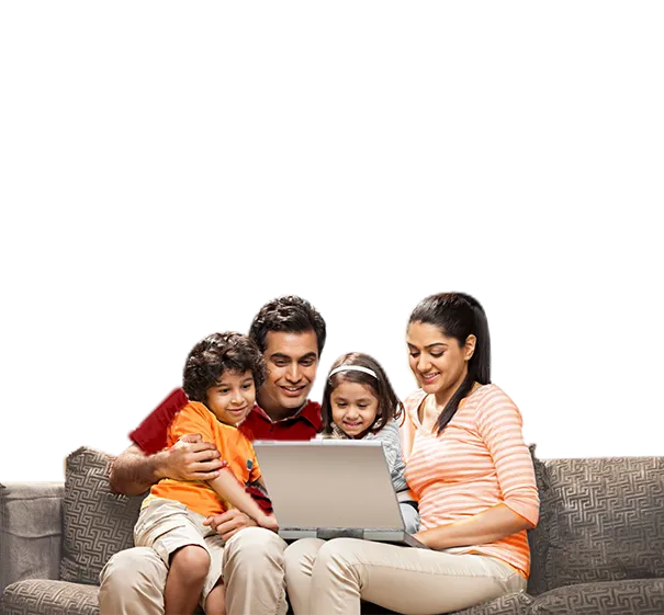 Family of four sitting on sofa using a laptop together.