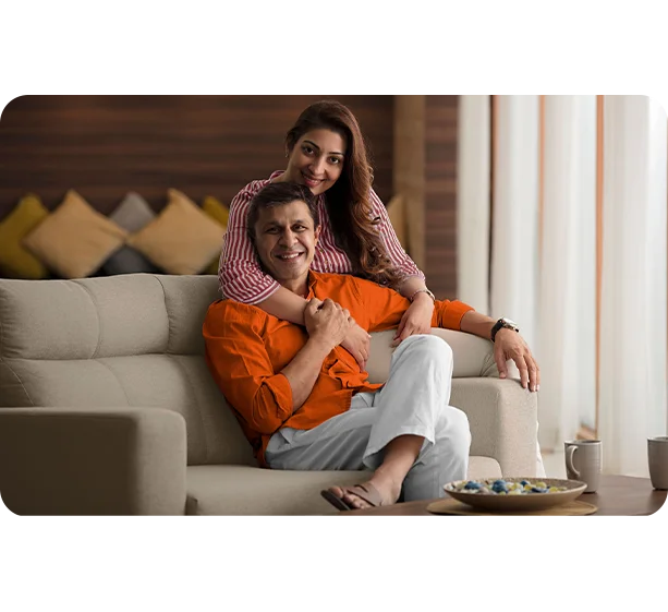 Happy senior couple relaxing at home, representing retirement wealth and comfort.