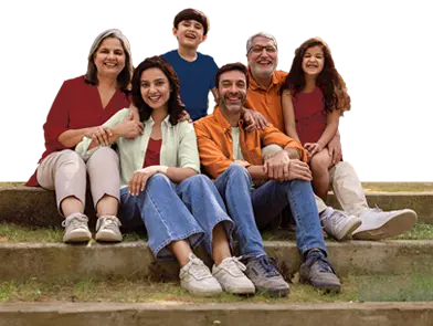 Smiling multi-generation family seated on outdoor steps, arms around each other, posing together happily.