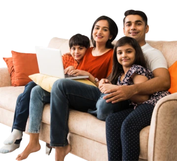 Happy family of four sitting on a sofa and using a laptop.
